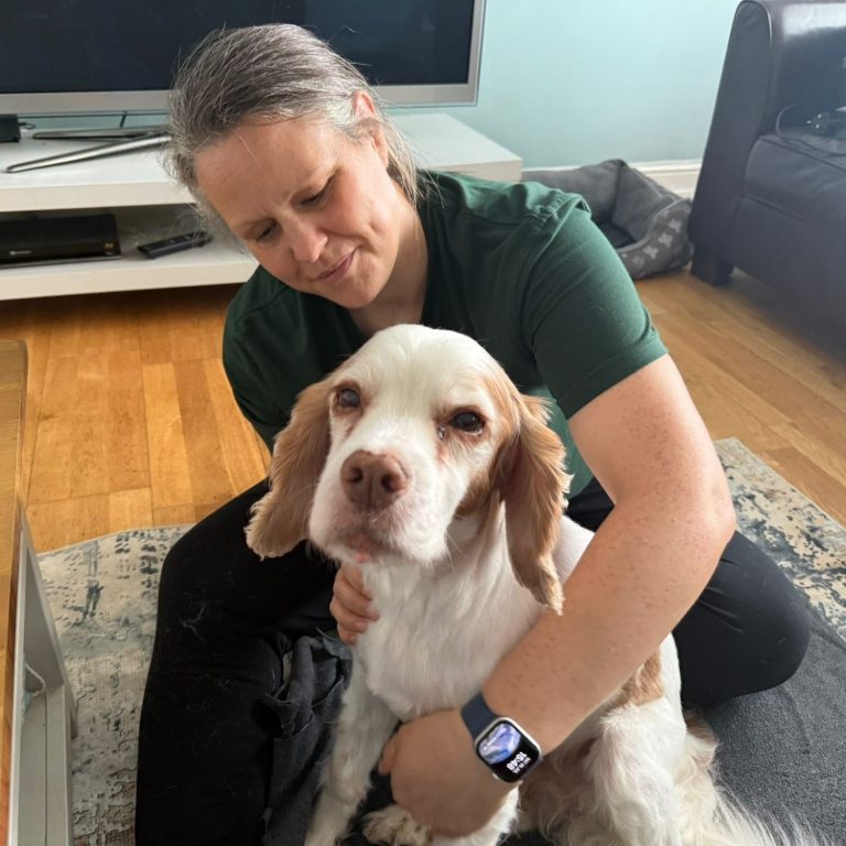 Liz and Lionel A woman gently interacts with a dog in a living room setting.